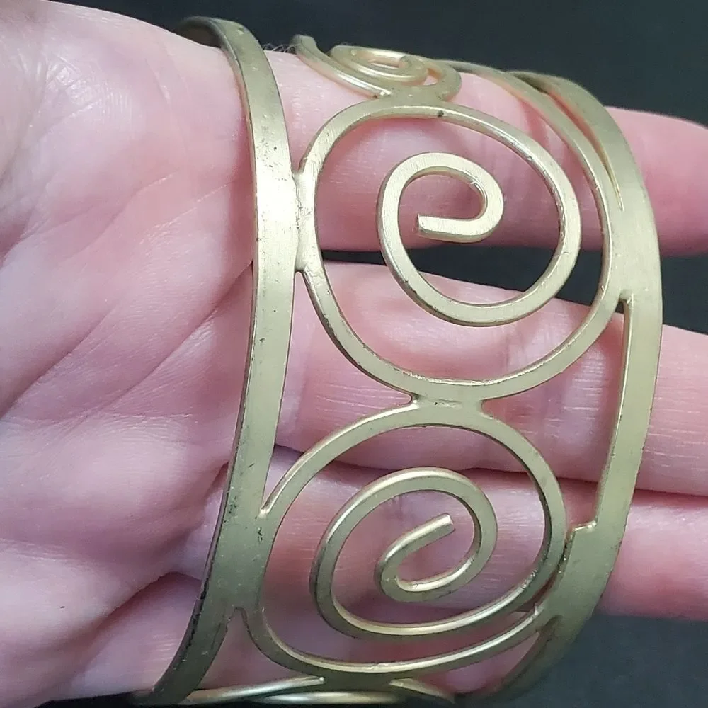 Gold tone swirly bangle cuff bracelet